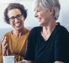 two women laughing and smiling at eachother