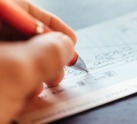 close up of a hand writing a check